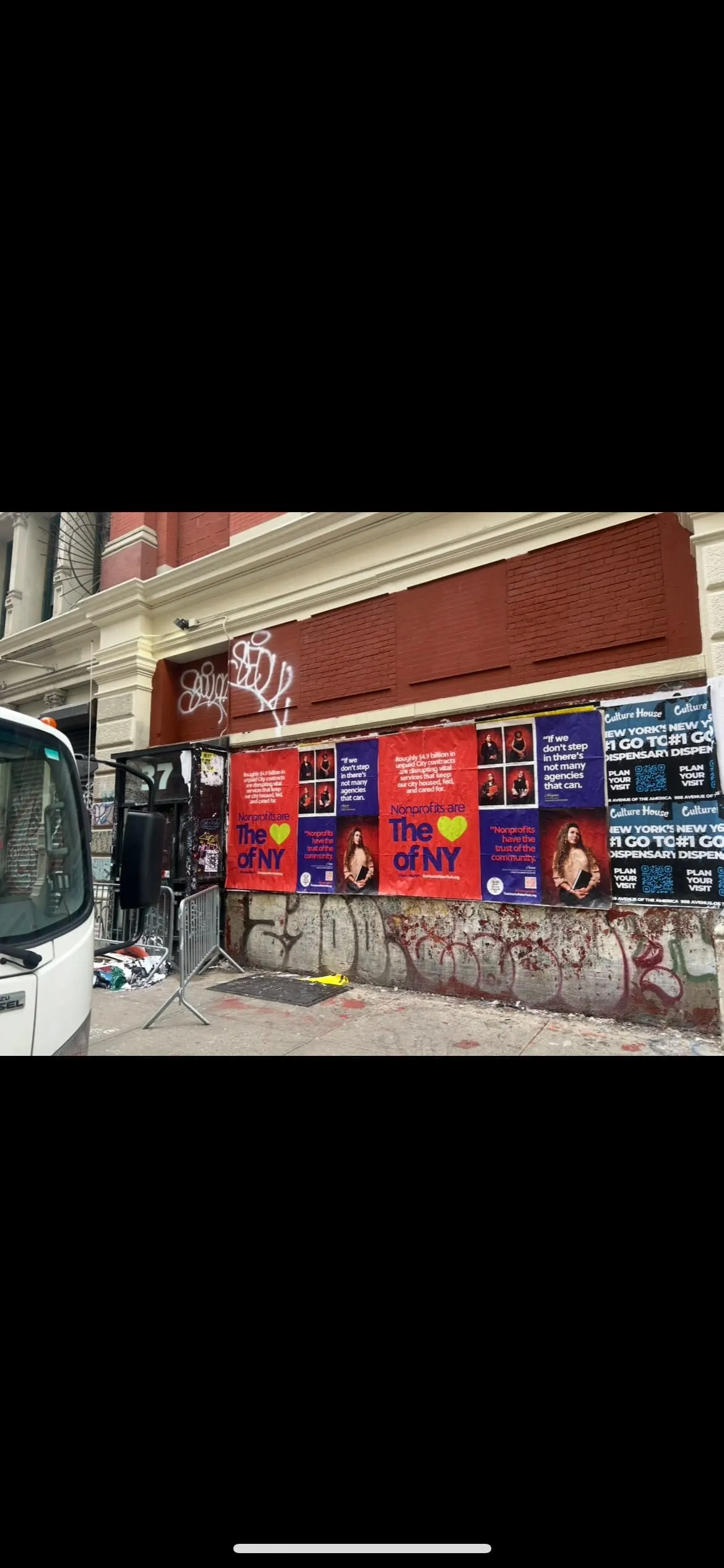 Wheatpaste poster install for 'Nonprofits are The Heart of NY' advocacy campaign on New York City, NY in New York City, New York City, red and blue posters about unpaid City contracts by Beyond Street Media