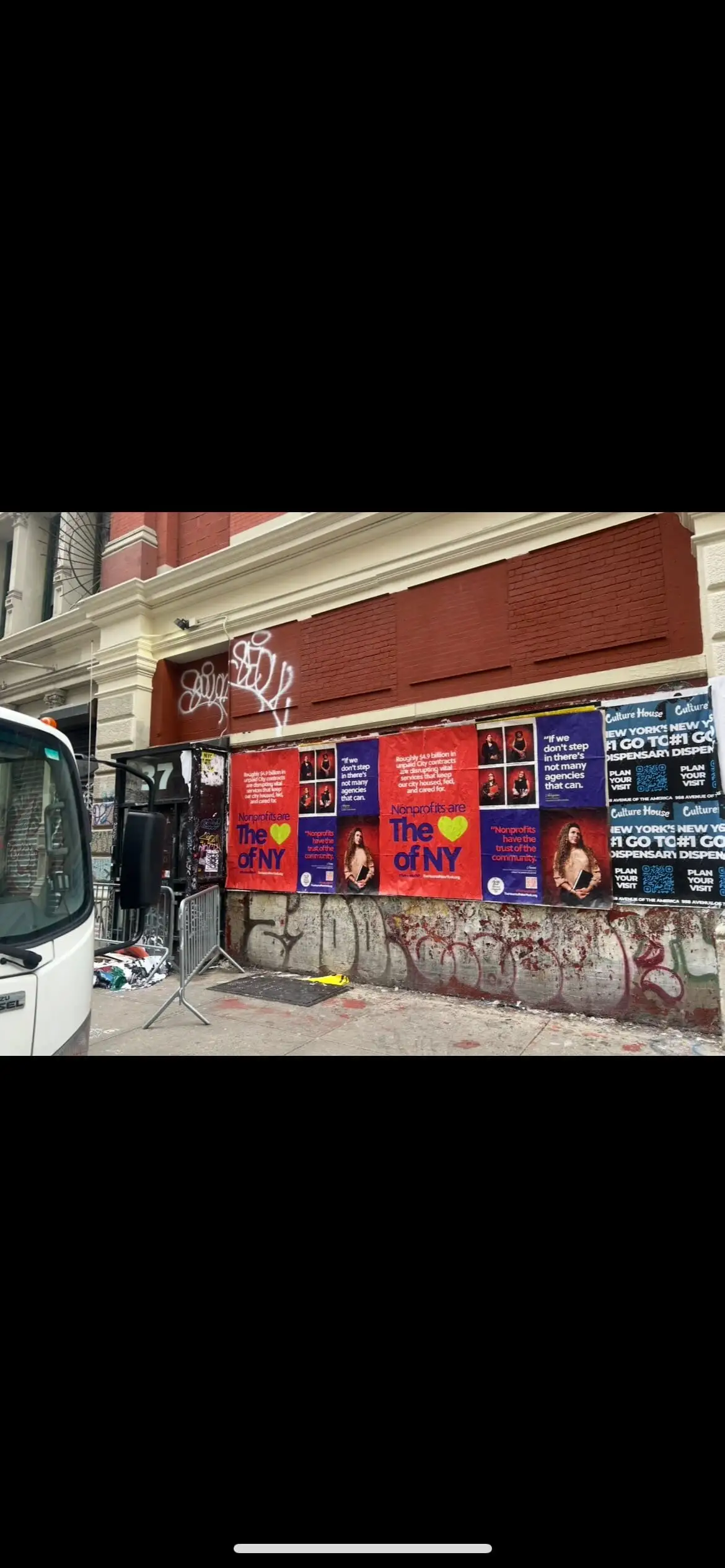 Wheatpaste poster install for 'Nonprofits are The Heart of NY' advocacy campaign on New York City, NY in New York City, New York City, red and blue posters about unpaid City contracts by Beyond Street Media