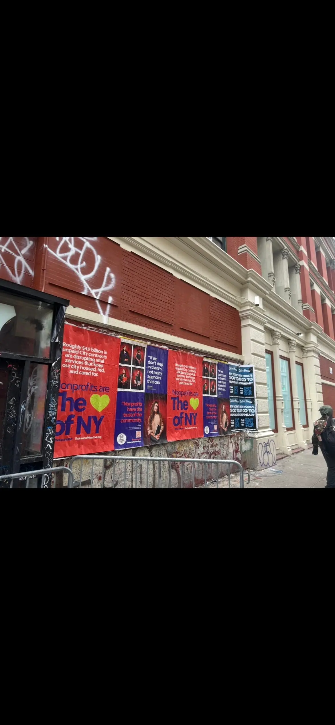 Wheatpaste poster install for 'Nonprofits are The Heart of NY' advocacy campaign on New York City, NY in New York City, New York City, red and blue posters about unpaid City contracts by Beyond Street Media