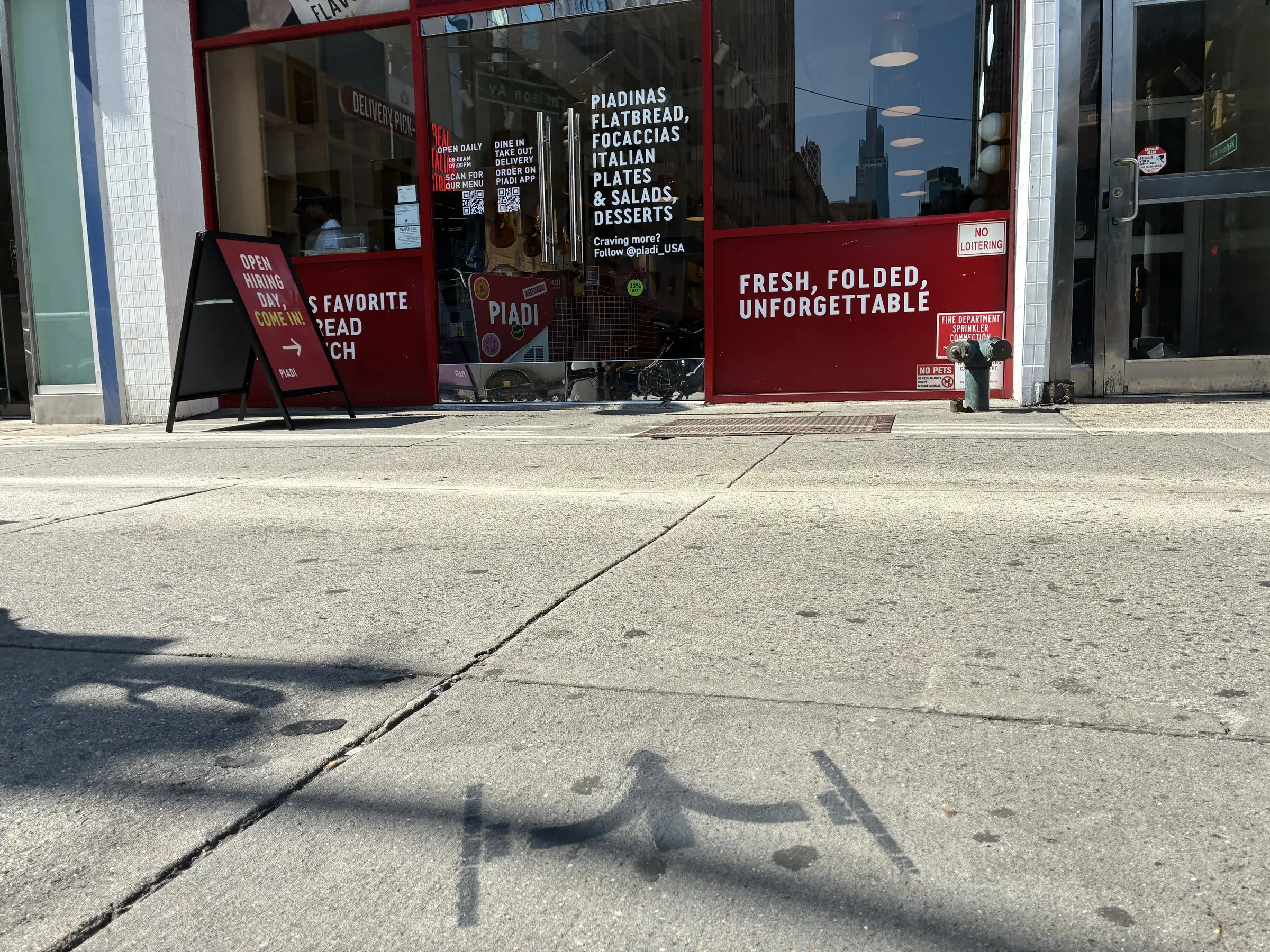PIADI La Piadineria storefront with a chalk stencil on the approach sidewalk, New York.