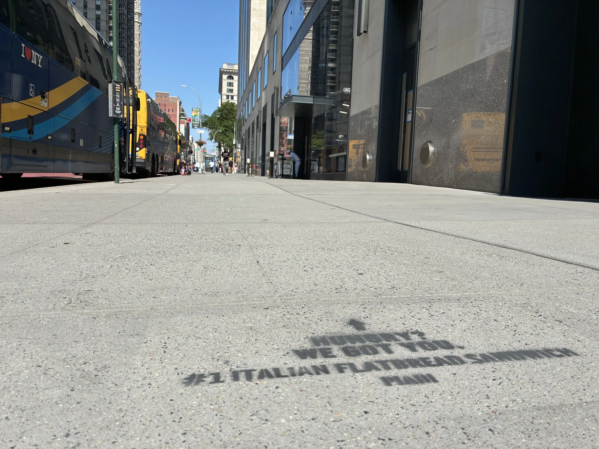 PIADI stencil reading Almost there, your next bite is waiting, with a pedestrian passing.
