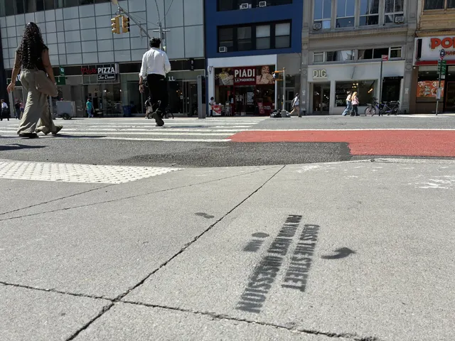 Directional arrow chalk stencils leading foot traffic across toward the PIADI storefront.
