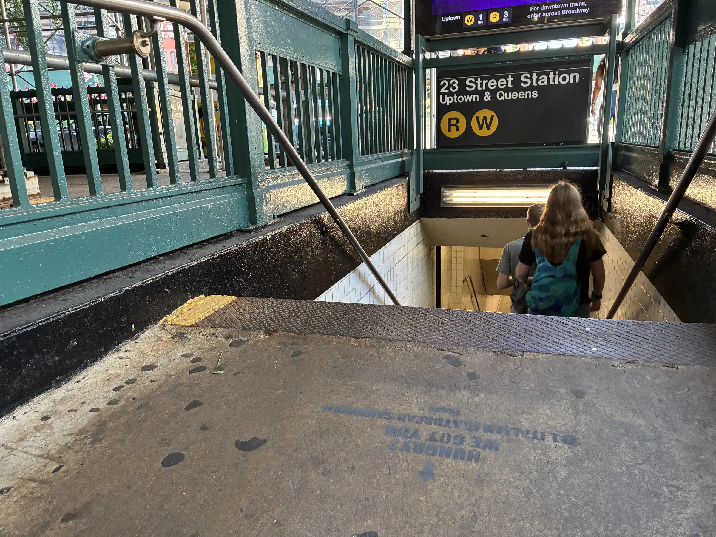 PIADI chalk stencil on the sidewalk at the 23rd St and Broadway subway entrance in New York by Beyond Street Media.