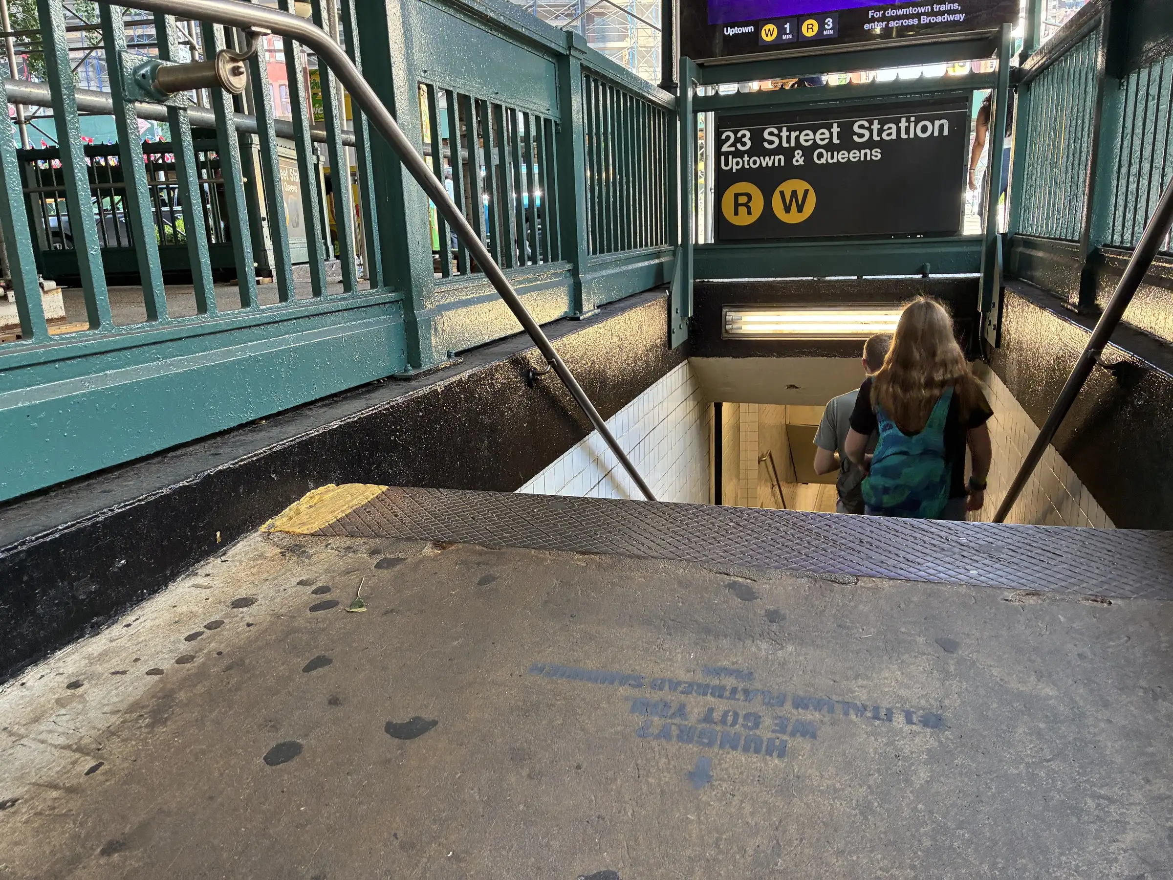 PIADI chalk stencil on the sidewalk at the 23rd St and Broadway subway entrance in New York by Beyond Street Media.