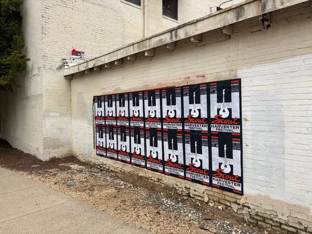 Scout Harvester wheatpaste in the dark colorway on a chipped white brick wall at Charlotte Rail Trail, South End, sixteen sheets