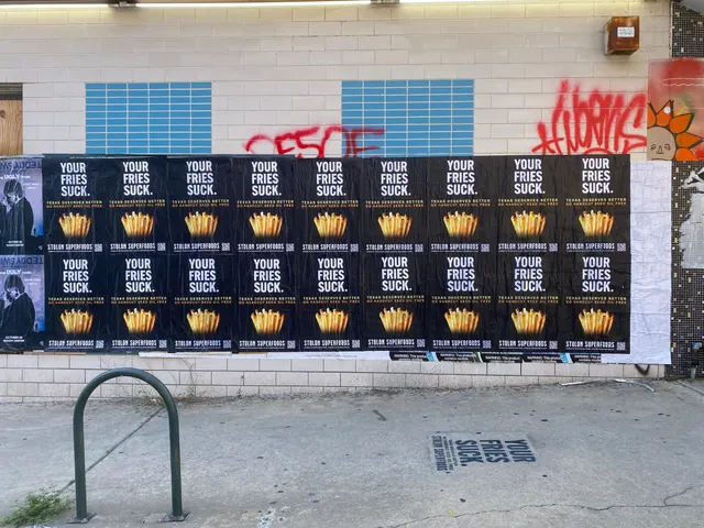Stolon Superfoods wheatpaste posters, eighteen in two rows of nine on glazed block, a black chalk stencil in front, on Lavaca Street, in daylight