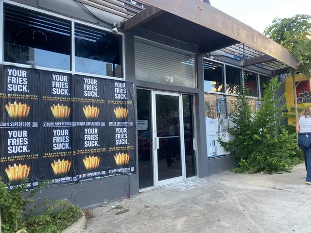 Stolon Superfoods wheatpaste posters, eight in two rows of four, on storefront windows by the 1710 door, on Lavaca Street at 16th, in daylight
