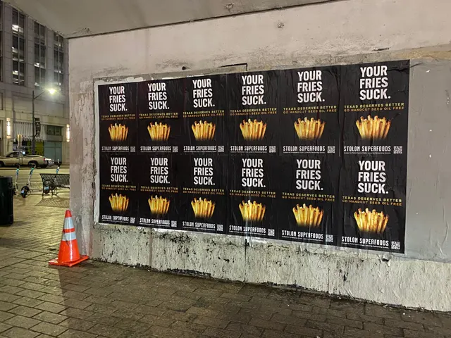 Stolon Superfoods wheatpaste posters, twelve head-on, each YOUR FRIES SUCK. over fries, on Congress Avenue at 5th, downtown, at night