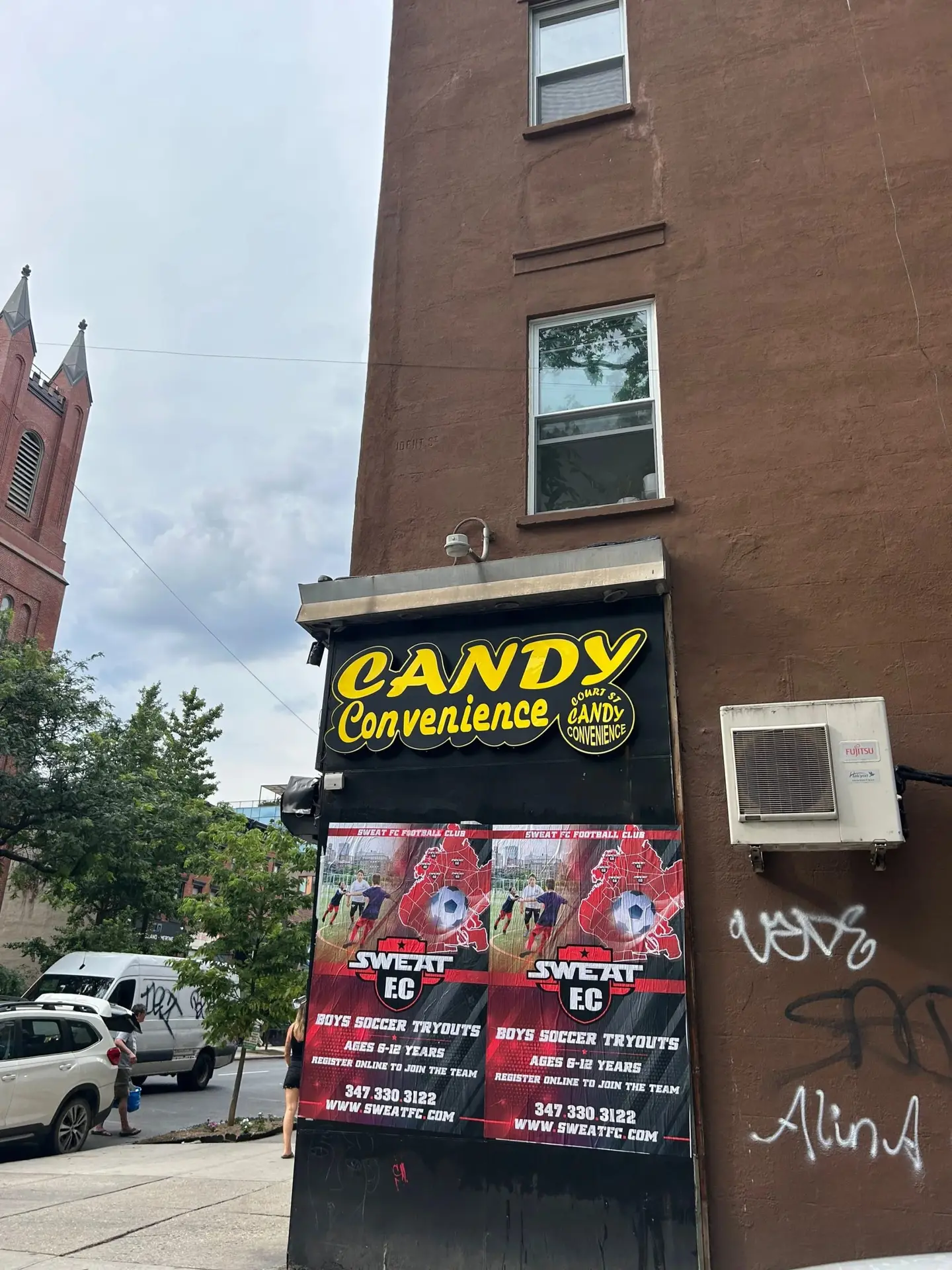 Wheatpaste poster install for Sweat FC youth soccer tryouts on Candy Convenience storefront in Bed-Stuy, Brooklyn, NY, red/black soccer-themed posters with phone number and URL by Beyond Street Media (photo 2 of 3).