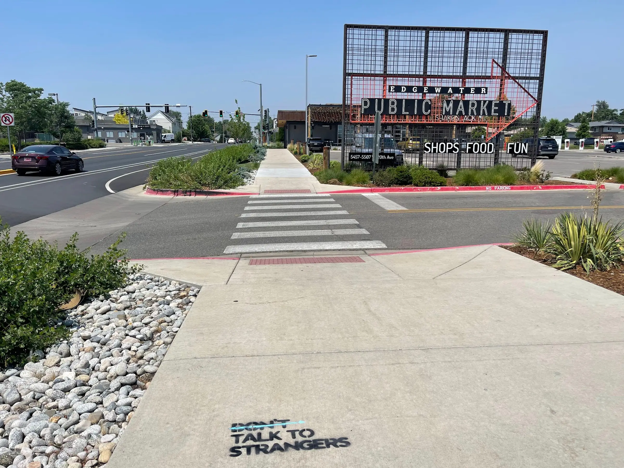 Talk to Strangers sidewalk decal install by Beyond Street Media at Adelitas Cocina Y Cantina Edgewater, Edgewater, Colorado — a 'TALK TO STRANGERS' sidewalk decal at a corner crosswalk.