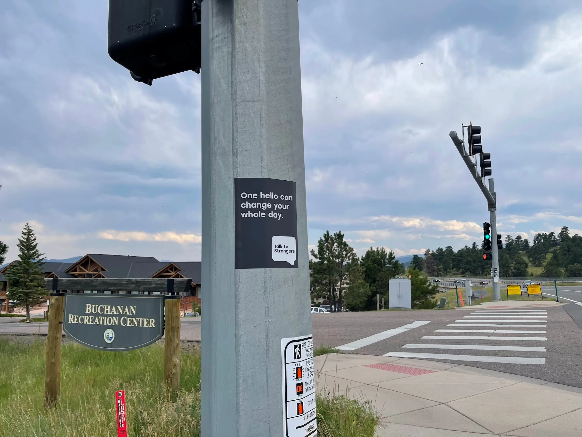 Talk to Strangers pole sticker install by Beyond Street Media at 32114 Ellingwood Trail, Evergreen, Colorado — a pole sticker at a signal pole by the Buchanan Recreation Center.