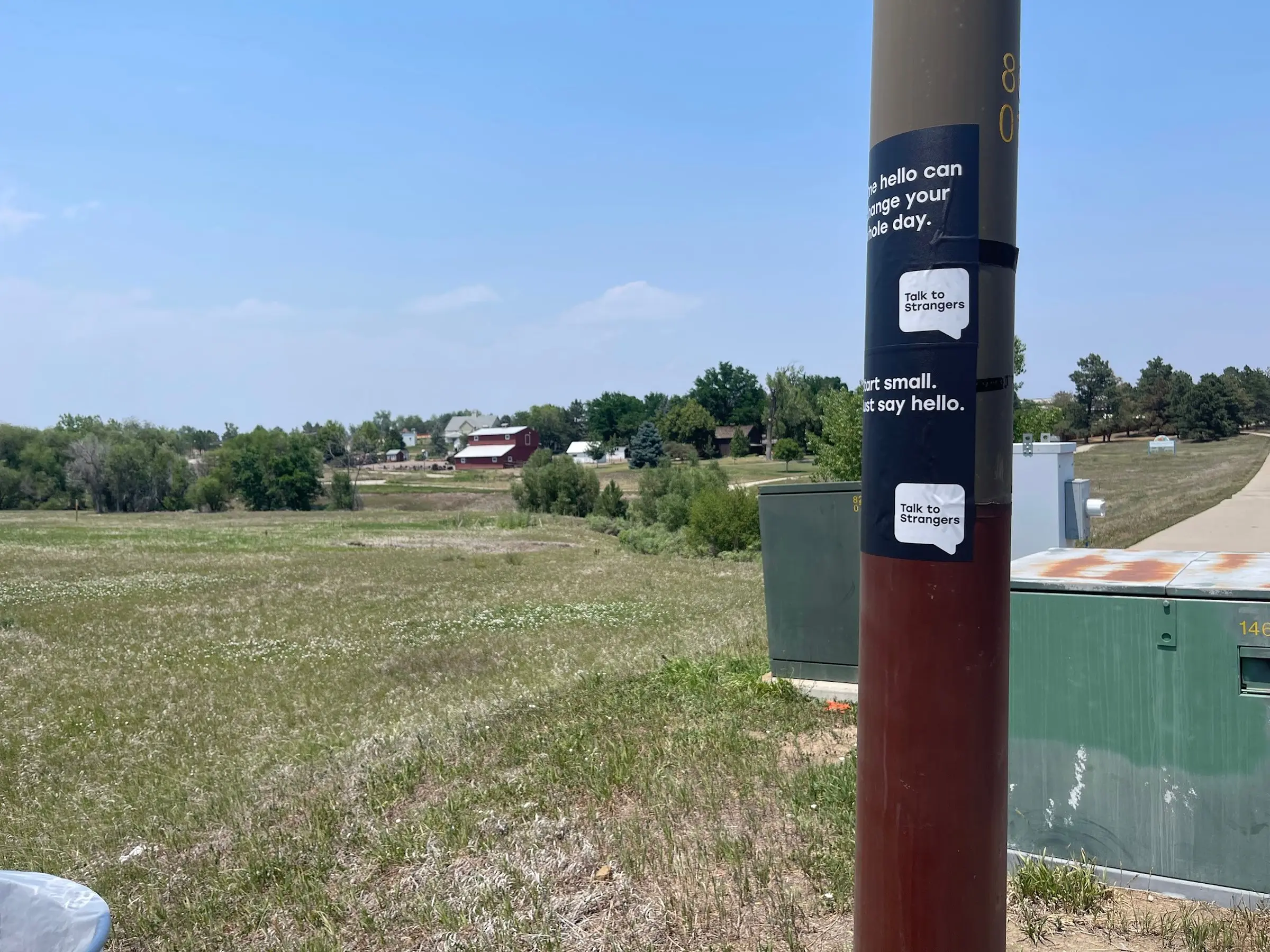Talk to Strangers pole sticker install by Beyond Street Media at S Wadsworth Blvd & W Kentucky Ave, Lakewood, Colorado — a pole sticker on a utility pole at a major intersection.