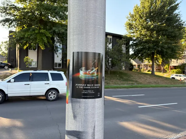 Johnny Blue Skies ashtray poster at Mill Street, Westport, golden late-day light on a metal pole in front of an apartment complex