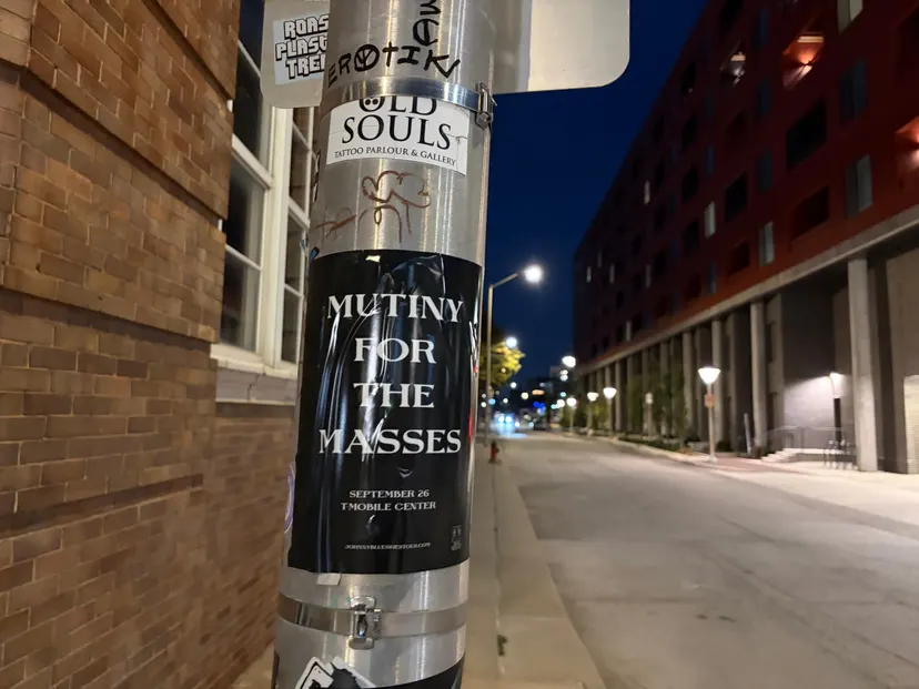 Mutiny for the Masses pole snipe at Southwest Boulevard, Crossroads, taped below an Old Souls Tattoo Parlour sign with the moon overhead