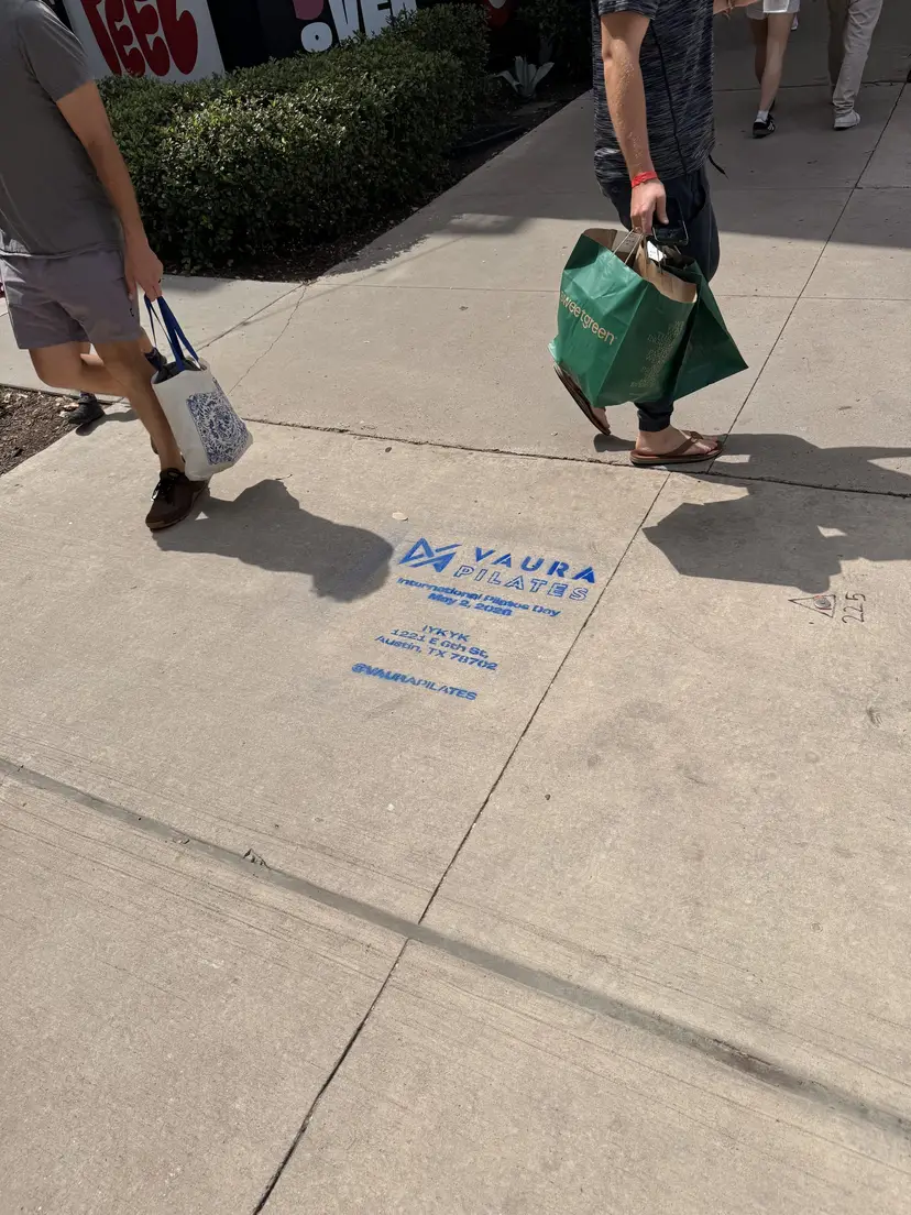 VAURA Pilates blue chalk-stencil on the East 6th Street sidewalk in Austin TX, VAURA Pilates Sidewalk Stencil Campaign Austin, by Beyond Street Media