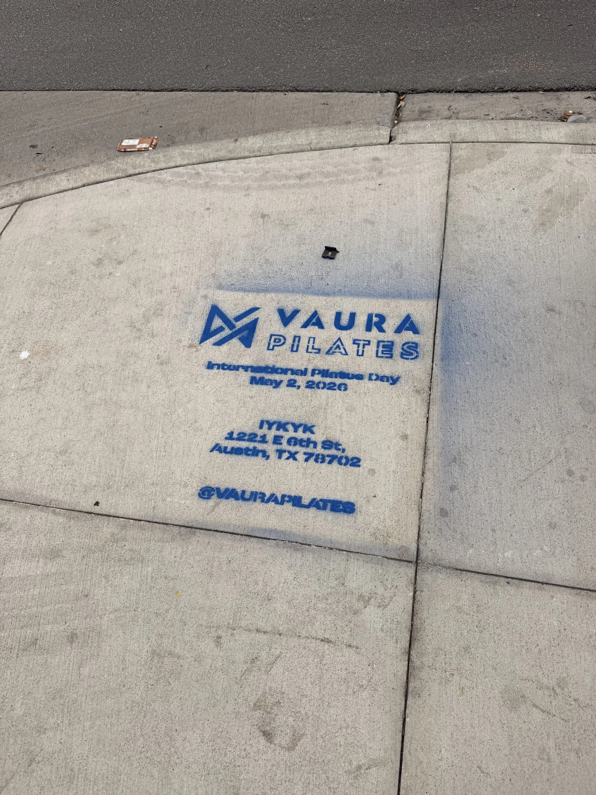 VAURA Pilates blue chalk-stencil on the East 6th Street sidewalk in Austin TX, documented street install, by Beyond Street Media