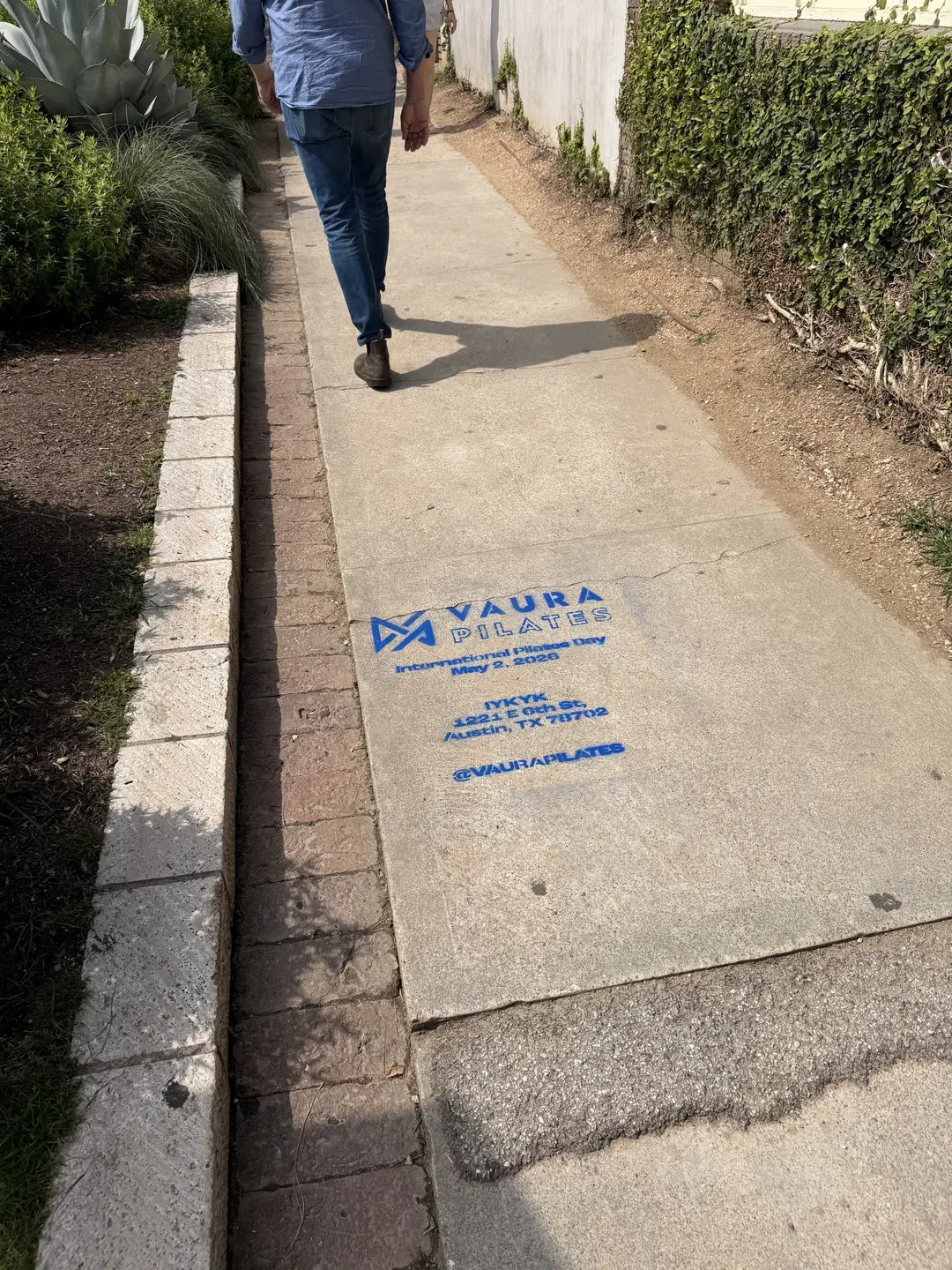 VAURA Pilates blue chalk-stencil on the East 6th Street sidewalk in Austin TX, documented street install, by Beyond Street Media (photo 4 of 9).