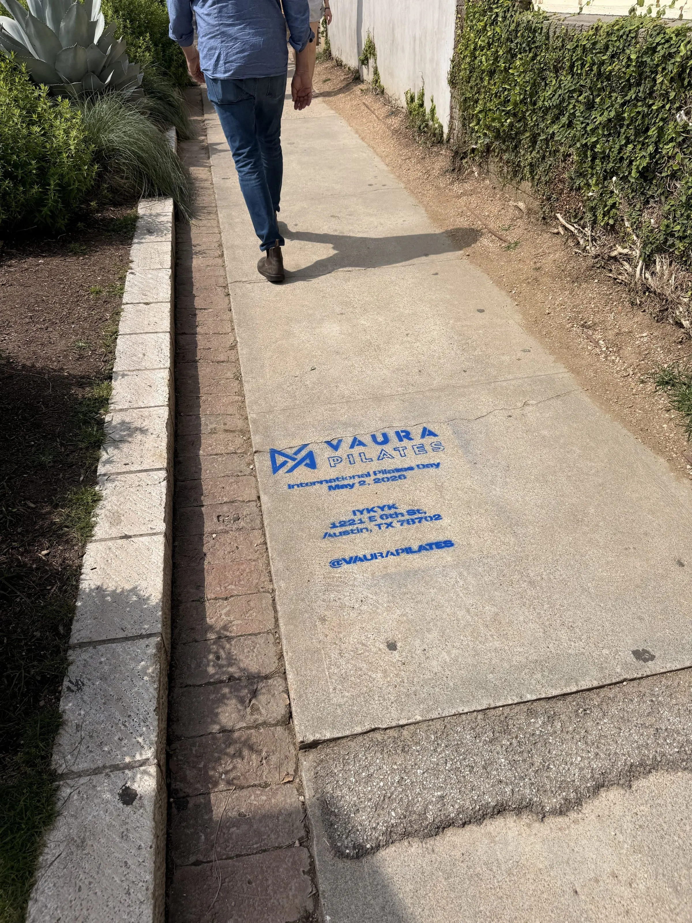 VAURA Pilates blue chalk-stencil on the East 6th Street sidewalk in Austin TX, documented street install, by Beyond Street Media