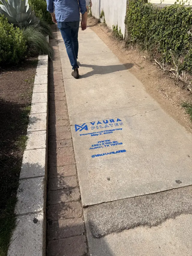 VAURA Pilates blue chalk-stencil on the East 6th Street sidewalk in Austin TX, documented street install, by Beyond Street Media (photo 4 of 9).