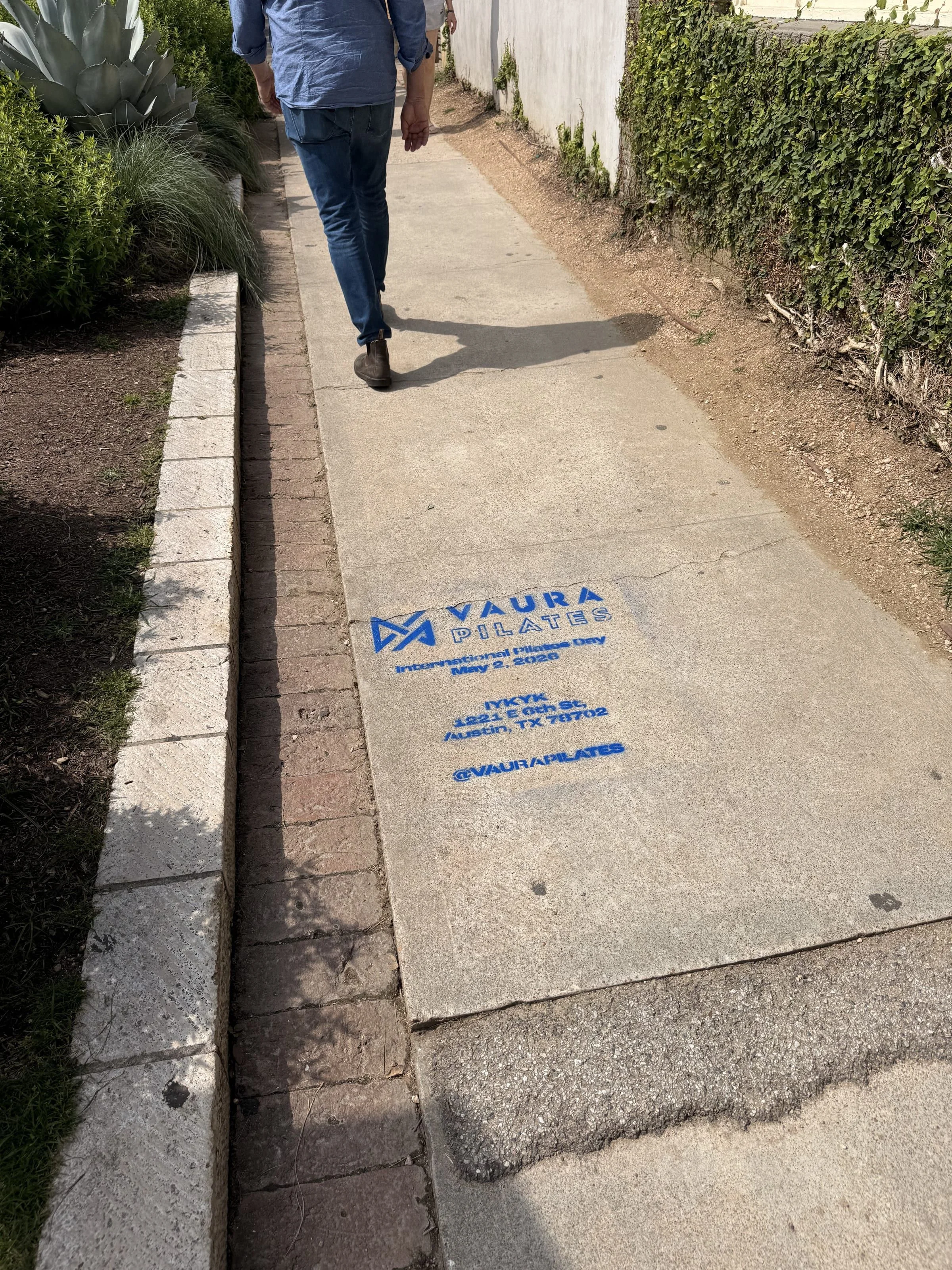 VAURA Pilates blue chalk-stencil on the East 6th Street sidewalk in Austin TX, documented street install, by Beyond Street Media