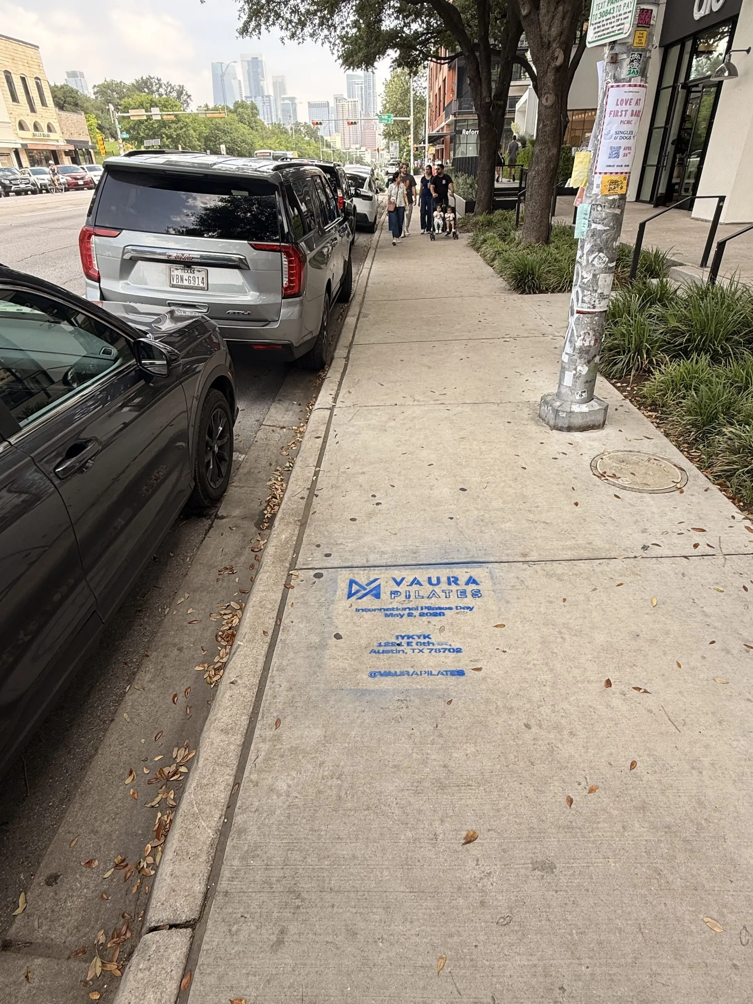 VAURA Pilates blue chalk-stencil on the East 6th Street sidewalk in Austin TX, documented street install, by Beyond Street Media