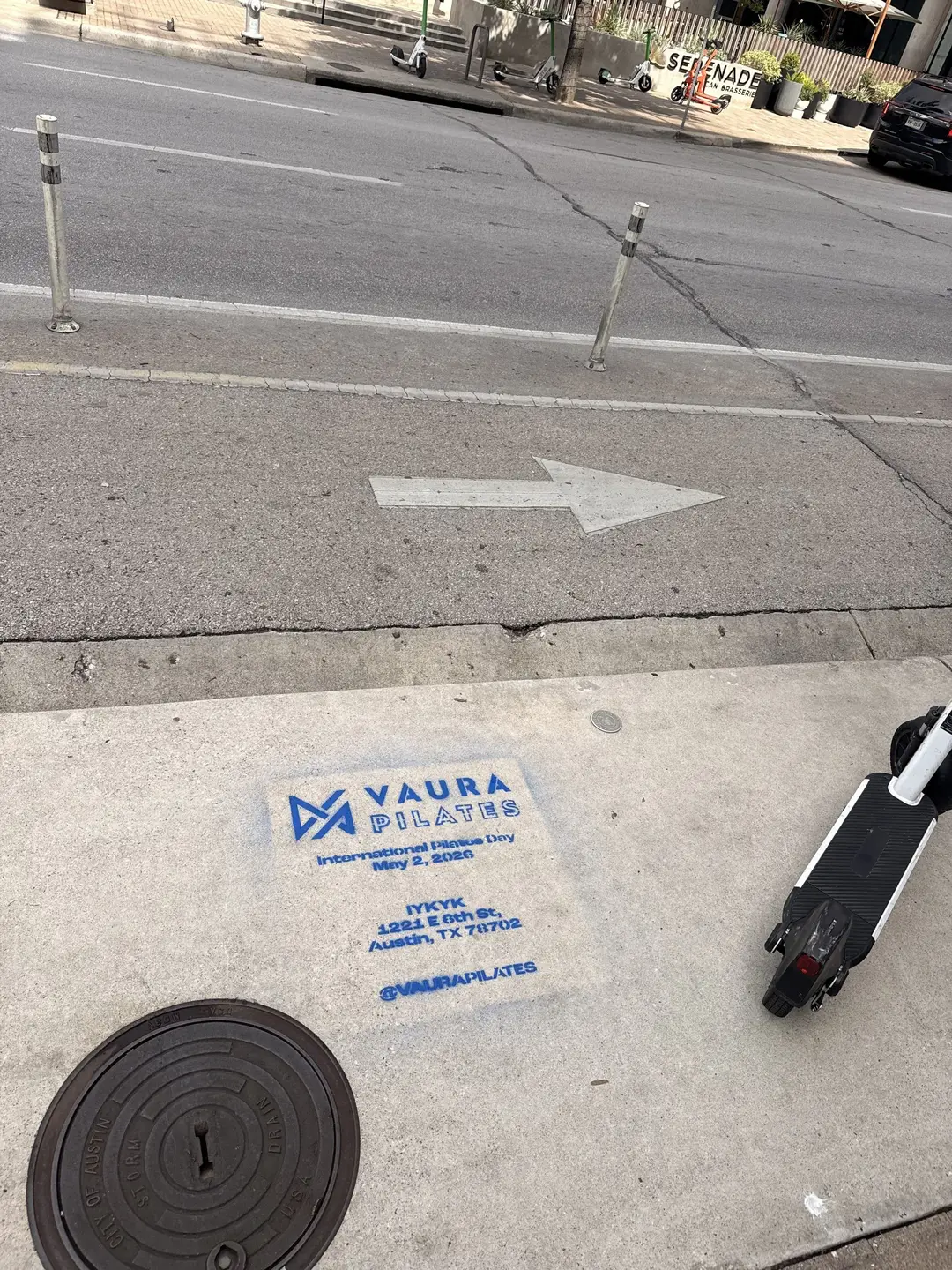 VAURA Pilates blue chalk-stencil on the East 6th Street sidewalk in Austin TX, documented street install, by Beyond Street Media (photo 6 of 9).