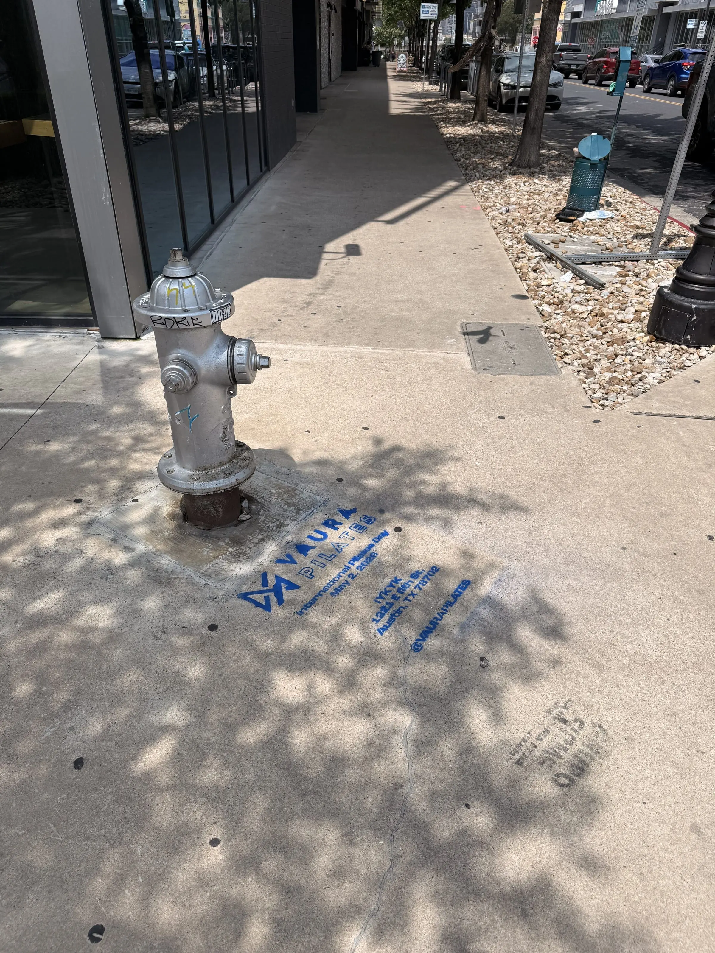VAURA Pilates blue chalk-stencil on the East 6th Street sidewalk in Austin TX, documented street install, by Beyond Street Media