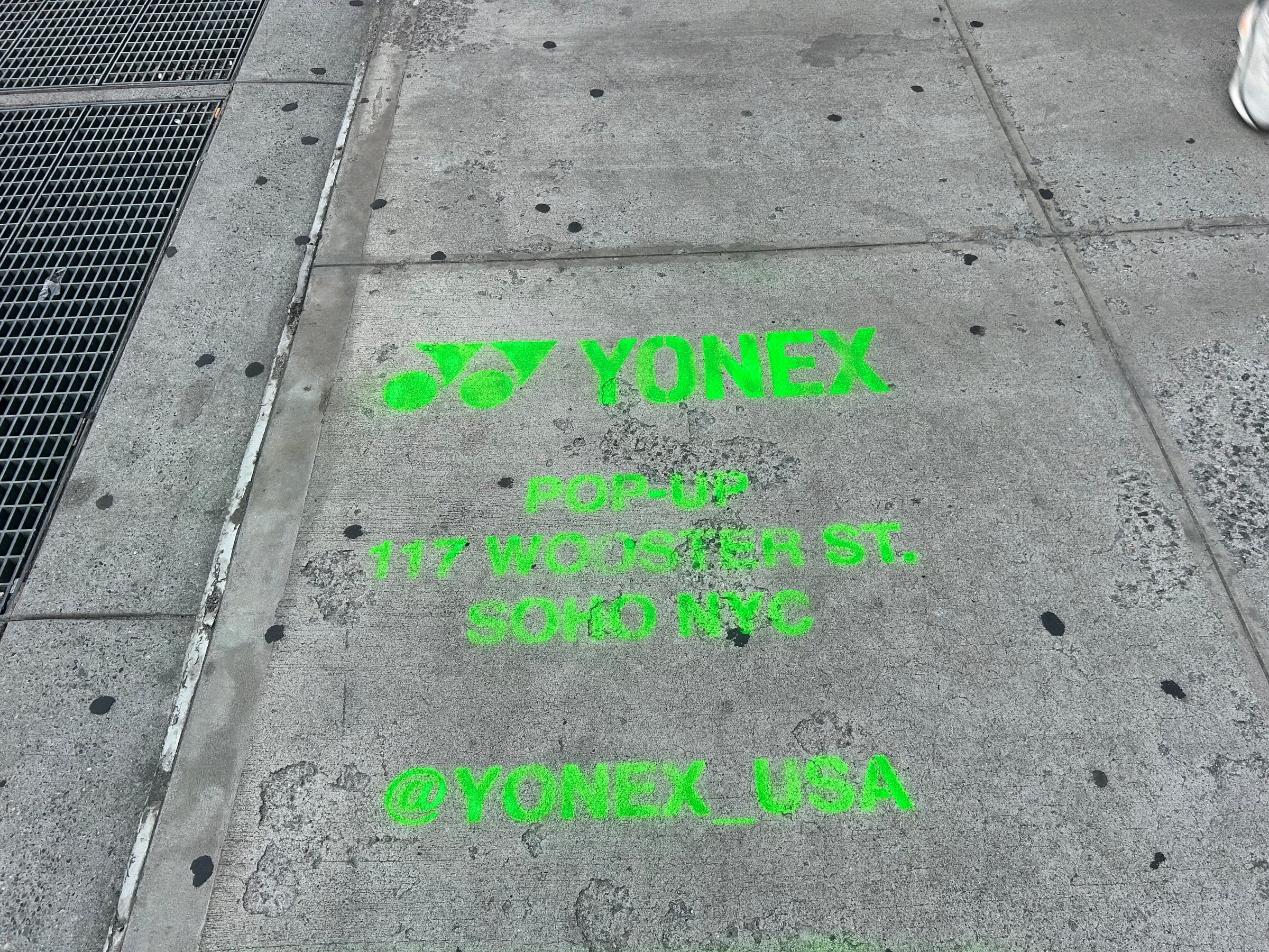 Yonex Pop-Up sidewalk stencil at 117 Wooster St, SoHo NYC — neon-green spray stencil by Beyond Street Media