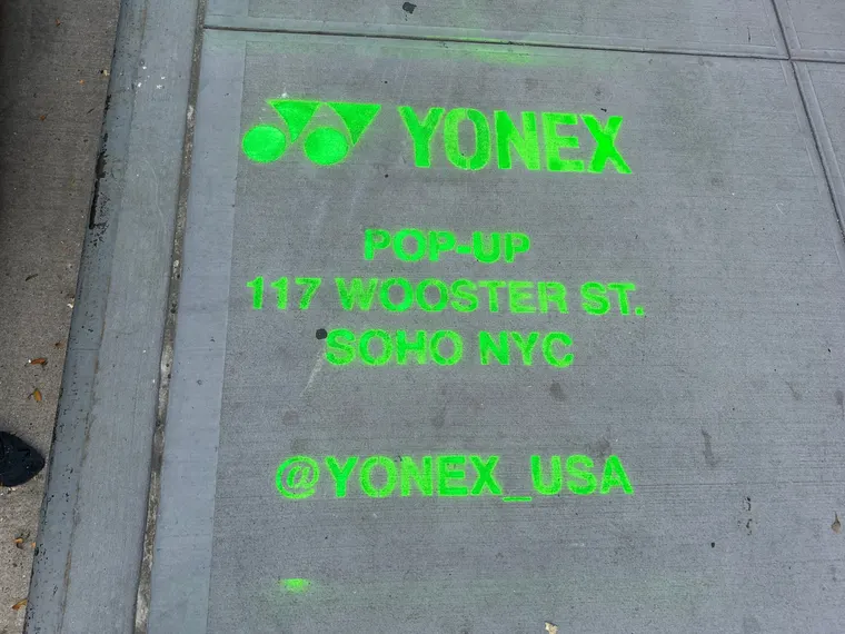 Yonex Pop-Up sidewalk stencil at 117 Wooster St, SoHo NYC - neon-green spray stencil by Beyond Street Media