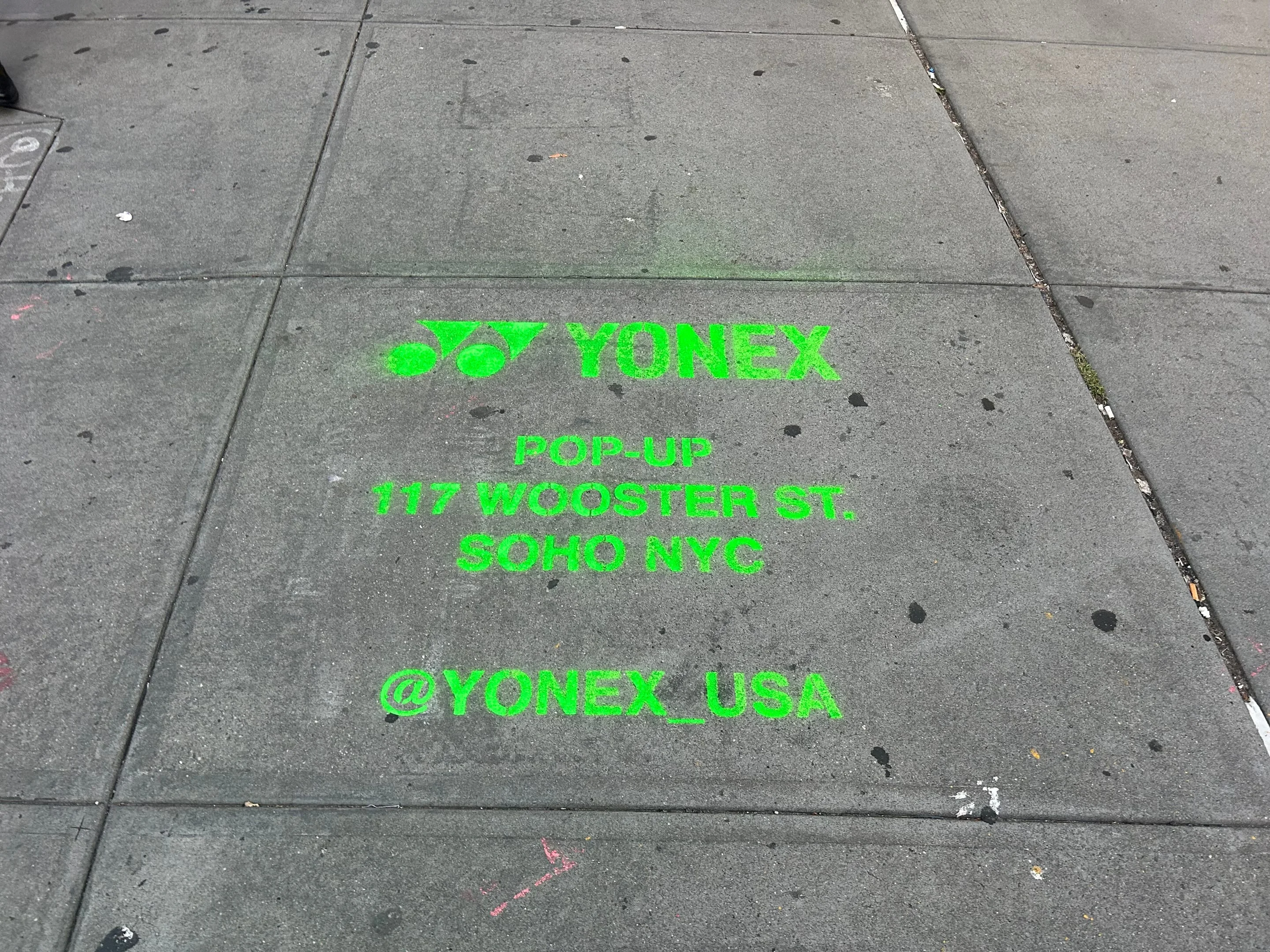 Yonex Pop-Up sidewalk stencil at 117 Wooster St, SoHo NYC - neon-green spray stencil by Beyond Street Media