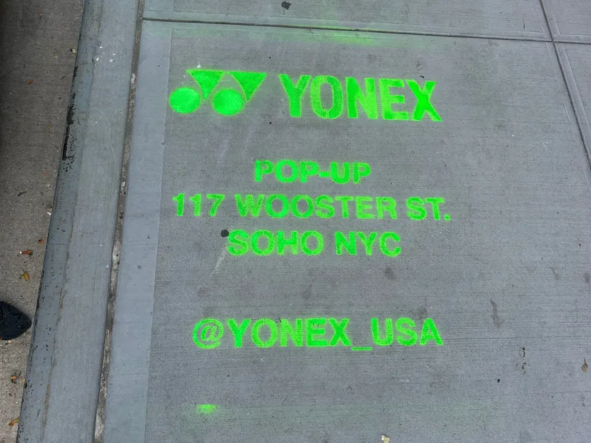 Yonex Pop-Up sidewalk stencil at 117 Wooster St, SoHo NYC - neon-green spray stencil by Beyond Street Media (photo 19 of 28).